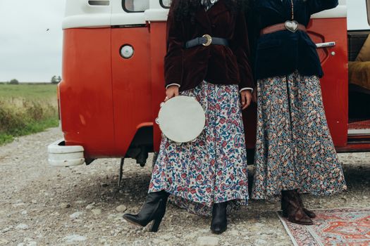 Dames in trendy festivaloutfits op een buitenfestival in Friesland met laagjes, boots en zomerse accessoires