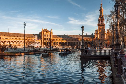Wandelende toeristen in de wijk Santa Cruz in Sevilla met tapasbars en zonnige straatjes